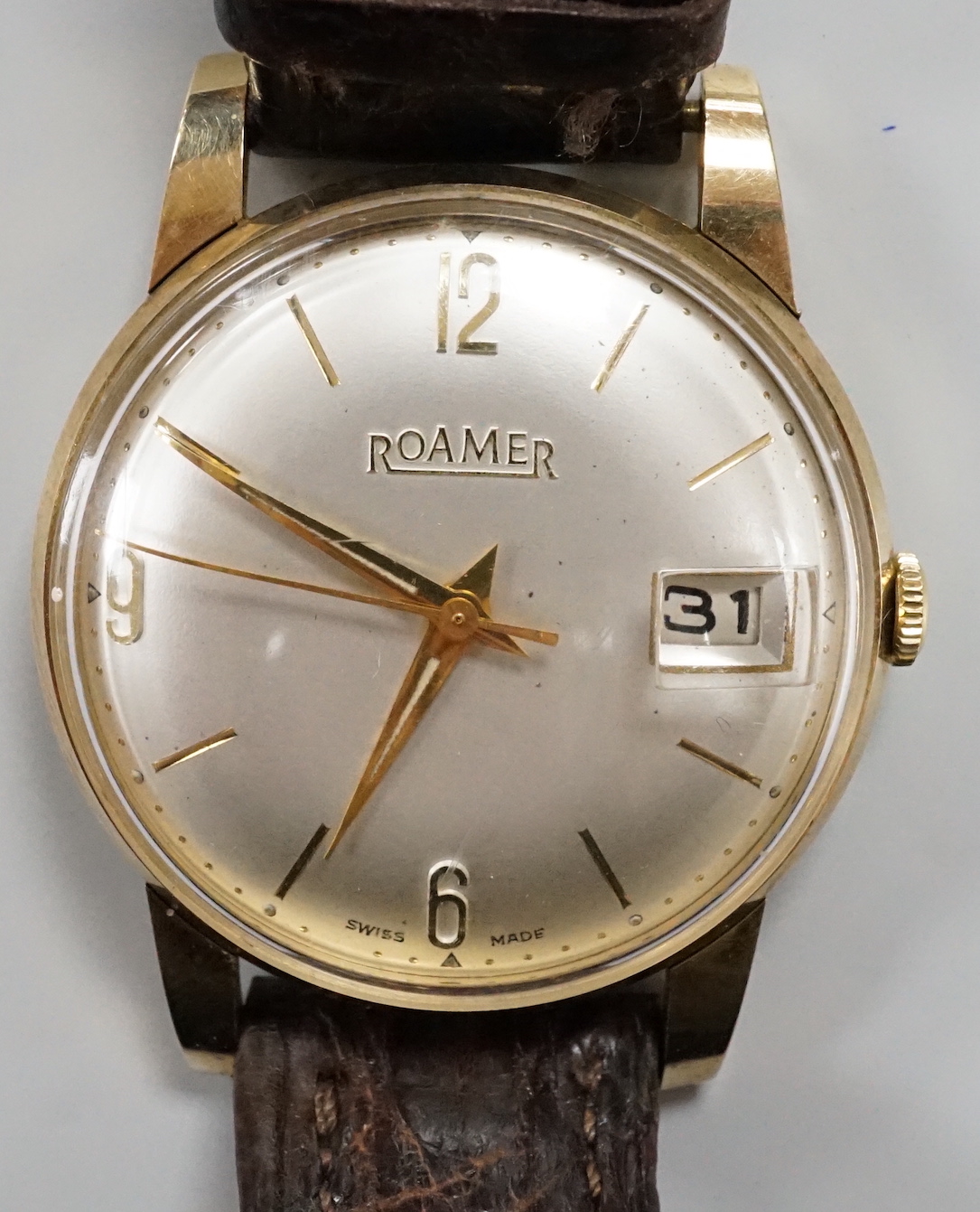 A gentleman's yellow metal Roamer manual wing wrist watch, with case back inscription, on a leather strap.